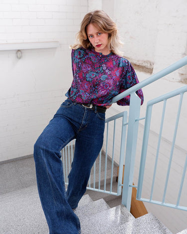 Lookin' for a way to make some '80s style magic? Slip on this vintage purple floral blouse with light shimmering accents and shoulder pads for a look that sparkles!