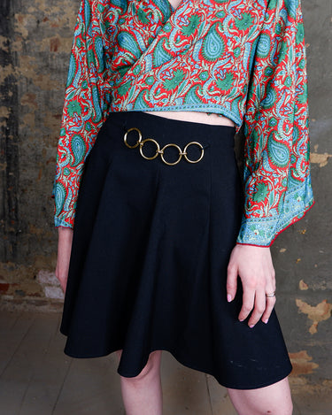 This vintage 90s mini skirt with bold gold ring details is a true statement piece with attitude. Vintage, but made for now.