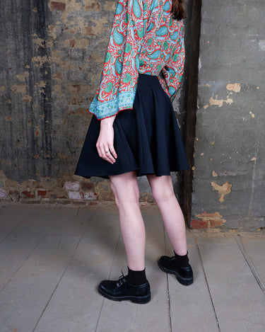 This vintage 90s mini skirt with bold gold ring details is a true statement piece with attitude. Vintage, but made for now.