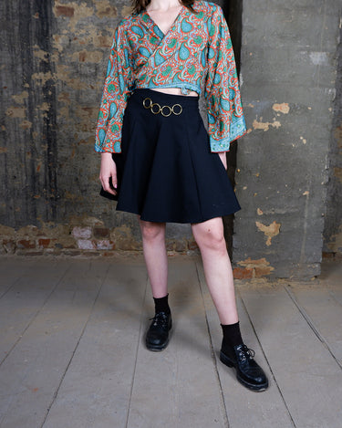 This vintage 90s mini skirt with bold gold ring details is a true statement piece with attitude. Vintage, but made for now.