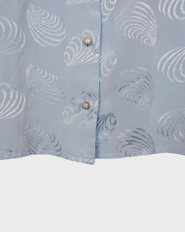 Introduce some sparkle to your style with this vintage 80s light blue blouse. The flattering fit, courtesy of the short sleeves and shoulder pads, meets a playful touch of shimmering pattern. Sparkle on!