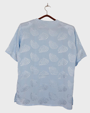 Introduce some sparkle to your style with this vintage 80s light blue blouse. The flattering fit, courtesy of the short sleeves and shoulder pads, meets a playful touch of shimmering pattern. Sparkle on!