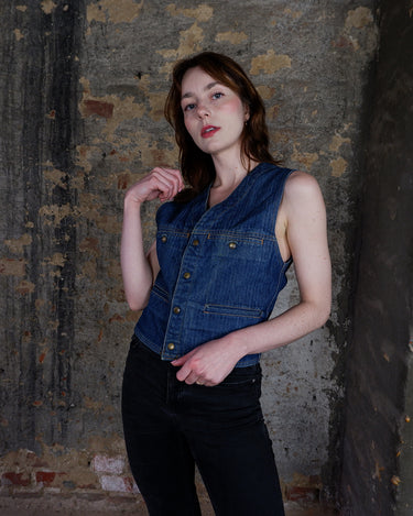 This vintage denim vest is tough, timeless, and ready to layer. It features classic brass snap buttons and four front pockets for that old-school workwear vibe.