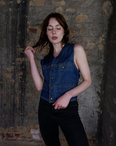 This vintage denim vest is tough, timeless, and ready to layer. It features classic brass snap buttons and four front pockets for that old-school workwear vibe.