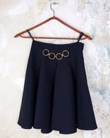 This vintage 90s mini skirt with bold gold ring details is a true statement piece with attitude. Vintage, but made for now.