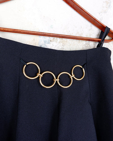This vintage 90s mini skirt with bold gold ring details is a true statement piece with attitude. Vintage, but made for now.