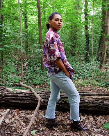 This 1990s Thai silk shirt with its chest pocket showcases a vibrant bird-and-leaf pattern in rich purples, reds, and blues. The luxurious silk fabric offers a smooth, lightweight feel with an eye-catching, exotic flair. Vintage, loud, and anything but boring.