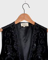 This vintage vest packs the perfect punch of 80s style! With its black velvet material and subtle shimmer of embroidered pailettes, you'll ready to sparkle.