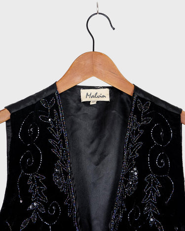 This vintage vest packs the perfect punch of 80s style! With its black velvet material and subtle shimmer of embroidered pailettes, you'll ready to sparkle.