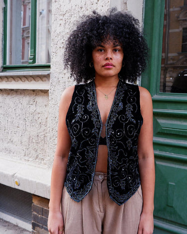 This vintage vest packs the perfect punch of 80s style! With its black velvet material and subtle shimmer of embroidered pailettes, you'll ready to sparkle.