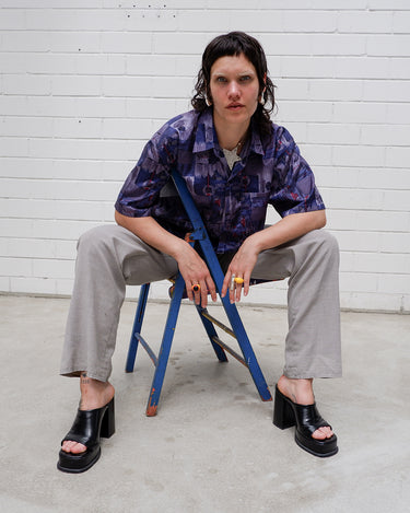 Bold, breezy, and silky smooth - this rare 90s short-sleeve gem by T. Corner is made from real Thai silk, brought to you by one of Thailand’s most renowned silk producers. The glossy fabric pops with a crazy pattern in electric purples and blues that’s impossible to ignore. Wear it loud, wear it proud