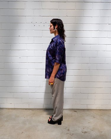 Bold, breezy, and silky smooth - this rare 90s short-sleeve gem by T. Corner is made from real Thai silk, brought to you by one of Thailand’s most renowned silk producers. The glossy fabric pops with a crazy pattern in electric purples and blues that’s impossible to ignore. Wear it loud, wear it proud