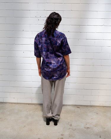 Bold, breezy, and silky smooth - this rare 90s short-sleeve gem by T. Corner is made from real Thai silk, brought to you by one of Thailand’s most renowned silk producers. The glossy fabric pops with a crazy pattern in electric purples and blues that’s impossible to ignore. Wear it loud, wear it proud