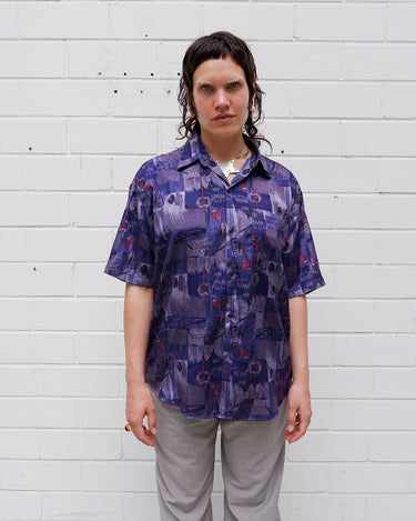 Bold, breezy, and silky smooth - this rare 90s short-sleeve gem by T. Corner is made from real Thai silk, brought to you by one of Thailand’s most renowned silk producers. The glossy fabric pops with a crazy pattern in electric purples and blues that’s impossible to ignore. Wear it loud, wear it proud!