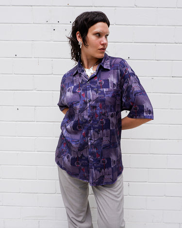 Bold, breezy, and silky smooth - this rare 90s short-sleeve gem by T. Corner is made from real Thai silk, brought to you by one of Thailand’s most renowned silk producers. The glossy fabric pops with a crazy pattern in electric purples and blues that’s impossible to ignore. Wear it loud, wear it proud!
