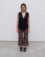 This Y2k black vest blends classic baroque style with a subtle gothic edge. The textured floral pattern and fleur-de-lis buttons give it a refined yet bold character. Cool, confident and a little unexpected – a standout piece without shouting.