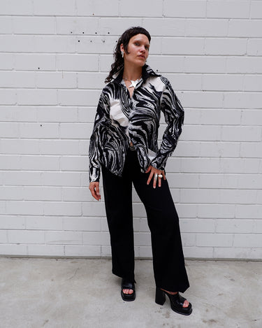 This black and white shirt doesn’t ask for attention — it just gets it. The abstract swirl pattern gives effortless chaos in the best way possible. Throw it on and let the print do the talking!