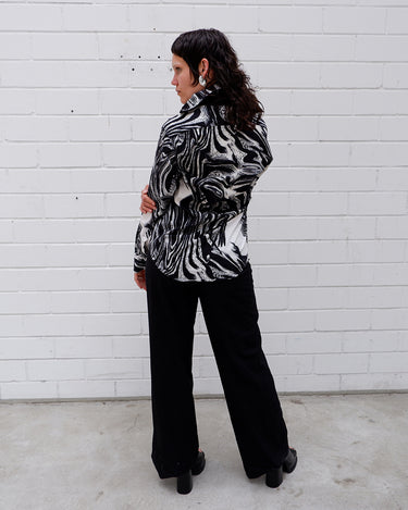 This black and white shirt doesn’t ask for attention — it just gets it. The abstract swirl pattern gives effortless chaos in the best way possible. Throw it on and let the print do the talking!