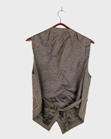 Fine beadwork and soft sequins give this 90s brown-grey waistcoat its understated shine – subtle, but impossible to miss. With a paisley satin back and belt, it’s a thoughtful piece for those who appreciate timeless style and fine detail.