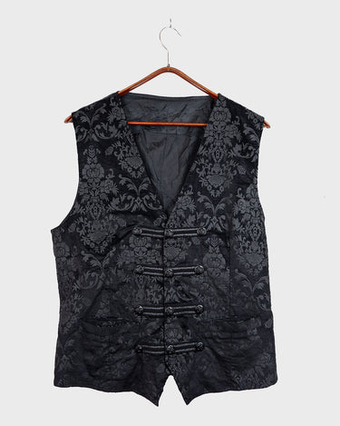 This Y2k black vest blends classic baroque style with a subtle gothic edge. The textured floral pattern and fleur-de-lis buttons give it a refined yet bold character. Cool, confident and a little unexpected – a standout piece without shouting.