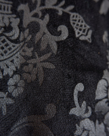 This Y2k black vest blends classic baroque style with a subtle gothic edge. The textured floral pattern and fleur-de-lis buttons give it a refined yet bold character. Cool, confident and a little unexpected – a standout piece without shouting.