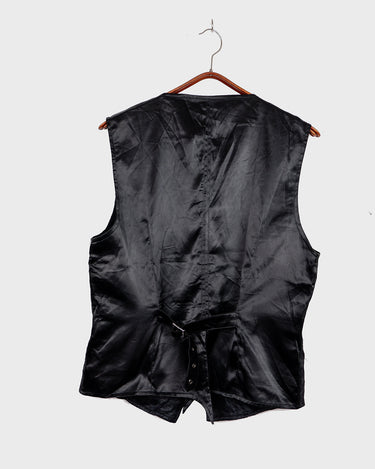 This Y2k black vest blends classic baroque style with a subtle gothic edge. The textured floral pattern and fleur-de-lis buttons give it a refined yet bold character. Cool, confident and a little unexpected – a standout piece without shouting.