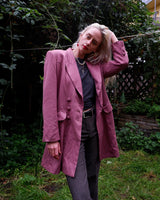 This vintage blazer in a striking dark pink is a must-have for any fashion-forward individual. Its long fit and two rows of buttons add a unique twist to any outfit. Whether you're dressing up for a formal event or adding some flair to your everyday look, this blazer has got you covered. (No time for boring fashion here!)