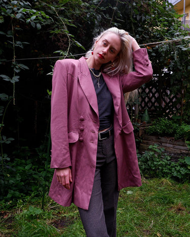 This vintage blazer in a striking dark pink is a must-have for any fashion-forward individual. Its long fit and two rows of buttons add a unique twist to any outfit. Whether you're dressing up for a formal event or adding some flair to your everyday look, this blazer has got you covered. (No time for boring fashion here!)
