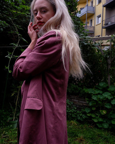 This vintage blazer in a striking dark pink is a must-have for any fashion-forward individual. Its long fit and two rows of buttons add a unique twist to any outfit. Whether you're dressing up for a formal event or adding some flair to your everyday look, this blazer has got you covered. (No time for boring fashion here!)