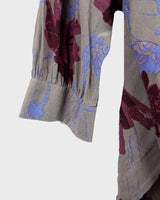 1980s vintage silk blouse with a loose fit and floral print in burgundy-violet on taupe. The silk adds a natural sense of luxury and ease. A laid-back piece with quiet elegance and vintage character.