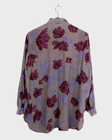 1980s vintage silk blouse with a loose fit and floral print in burgundy-violet on taupe. The silk adds a natural sense of luxury and ease. A laid-back piece with quiet elegance and vintage character.