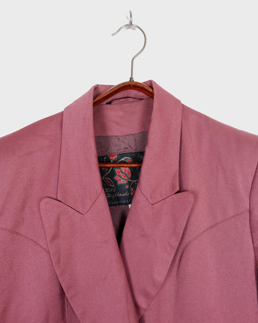 This vintage blazer in a striking dark pink is a must-have for any fashion-forward individual. Its long fit and two rows of buttons add a unique twist to any outfit. Whether you're dressing up for a formal event or adding some flair to your everyday look, this blazer has got you covered. (No time for boring fashion here!)