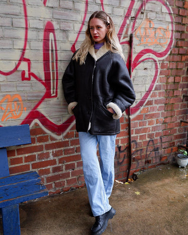 Wrap yourself in cozy luxury with this Premium Vintage 80s black leather shearling coat. This timeless coat has all the bells and whistles for an edgy winter look with maximum comfort! Ready for all that cold-weather fun in this coat?