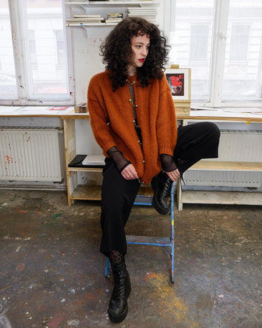 Add a playful touch to your wardrobe with this vintage 80s brown woolmix cardigan, handmade with love. The 3/4 sleeve length and golden buttons make it stand out from the rest.