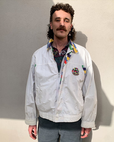 This vintage Missoni Sport windbreaker from the 90s is a standout piece with its bold striped accents and iconic globe logo embroidery. Made in Italy and cut in a comfortable size L, it offers a relaxed fit and lightweight feel – ideal for everyday wear. A rare example of Missoni’s sporty aesthetic, combining timeless design with a splash of color. Effortlessly cool and easy to style.
