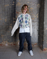 This ultra-soft vintage sweater from the 80s/90s features a cozy lana-wool knit and a playful argyle pattern in muted greens, purples, blues and earthy tones. Its relaxed cream base makes the colorful diamonds pop, giving the piece a effortlessly wearable look.