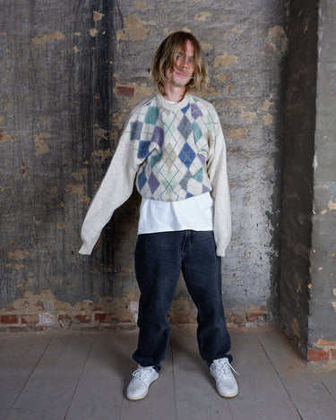 This ultra-soft vintage sweater from the 80s/90s features a cozy lana-wool knit and a playful argyle pattern in muted greens, purples, blues and earthy tones. Its relaxed cream base makes the colorful diamonds pop, giving the piece a effortlessly wearable look.