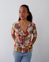 a woman is wearing a Vintage 80s 90s floral colorful short sleeve button blouse size M from the online shop www.vintivintage.com