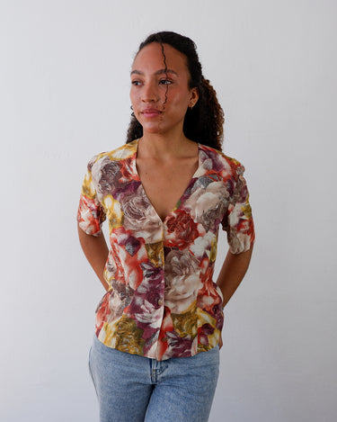 a woman is wearing a Vintage 80s 90s floral colorful short sleeve button blouse size M from the online shop www.vintivintage.com