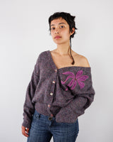 a woman is wearing a vintage 80s 90s melange purple cardigan with pink floral applique size M-L from the online shop vinti vintage