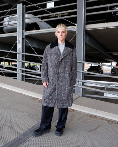 This long checked overcoat in grey tones with subtle red accents combines classic tailoring with a modern edge. The soft real fur collar adds warmth and texture, while the relaxed fit ensures versatile styling. Ideal for elevating everyday looks in cooler weather.