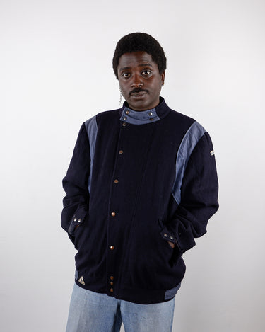 a man is wearing a Vintage 80s navy blue FRANK POINT woolmix jacket in L-XL from the vintage online shop www.vintivintage.com