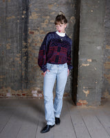 This vintage 80s sweater has it all: rich shades of purple, red, and black wrapped into a playful mix of geometric and paisley patterns. The colors have a slightly muted, matte look that gives the piece a very specific, effortlessly cool aesthetic. Perfect for anyone who loves vibes with a soft, lived-in feel.