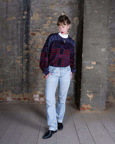 This vintage 80s sweater has it all: rich shades of purple, red, and black wrapped into a playful mix of geometric and paisley patterns. The colors have a slightly muted, matte look that gives the piece a very specific, effortlessly cool aesthetic. Perfect for anyone who loves vibes with a soft, lived-in feel.