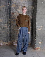 This vintage Rasica knit sweater showcases an elegant blend of warm brown tones, highlighted by a refined vertical ribbed pattern for a structured look. Its texture and subtle detailing, including a small chest pocket accent, underline its timeless, professional aesthetic. A piece for elevated casual wear.