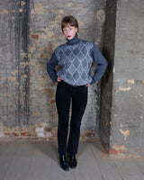 This vintage wool blend sweater features a classic grey color palette with an elegant argyle diamond pattern, offering a timeless look. Designed with a cozy turtleneck and ribbed cuffs, it's perfect for your everyday wearability. A knit piece ideal cold-season layering.