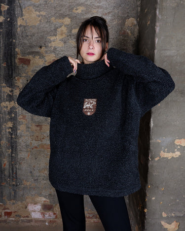 Cuddle up in this Vintage 90s South Pole fleece turtleneck pullover in dark grey (almost black), bringing laid-back vibes and authentic 90s vintage style. The soft fleece fabric and relaxed fit make it perfect for effortless comfort. A timeless piece for everyday wearability.