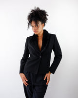 a woman is wearing a Vintage 90s black blazer with faux fur collar and shoulder pads in S-M from the online shop vinti vintage