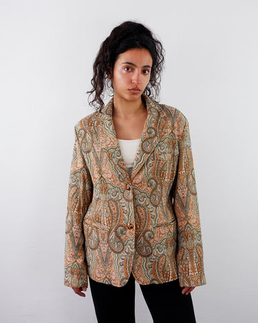 a woman is wearing a Vintage 90s colorful paisley pattern blazer with shoulder pads | S-M from the online shop www.vintivintage.com