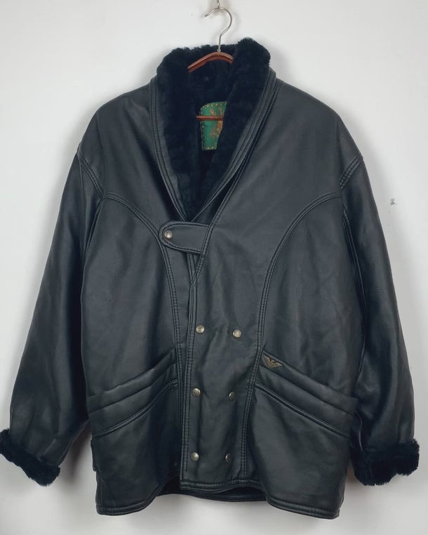 Experience timeless style with this Vintage 80s black faux leather shearling coat, featuring a warm lining that will keep you cozy. Just a heads up, the sleeves are not lined for extra warmth.